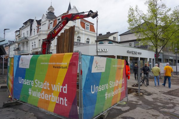 Hinter einer Baustellenabsperrung steht ein Bagger