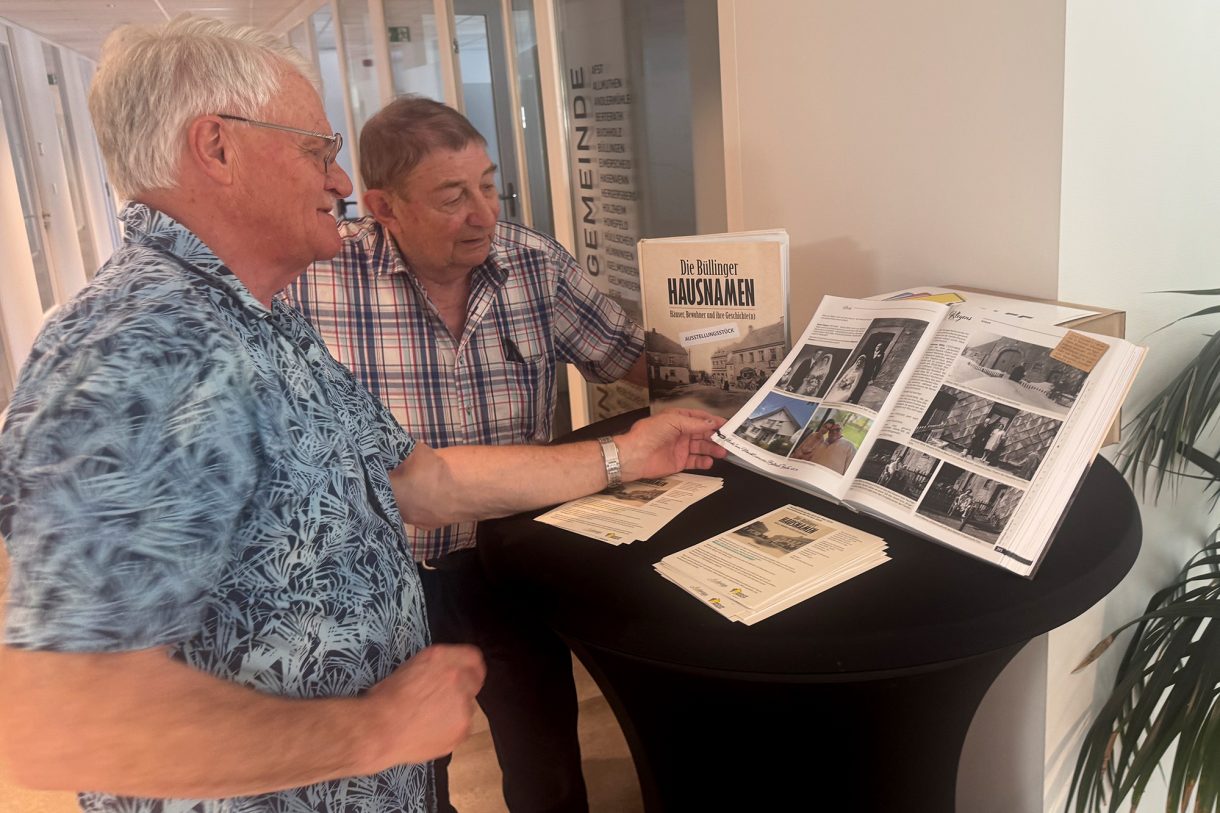 Willy Jost und Manfred Lauter blättern in dem Buch