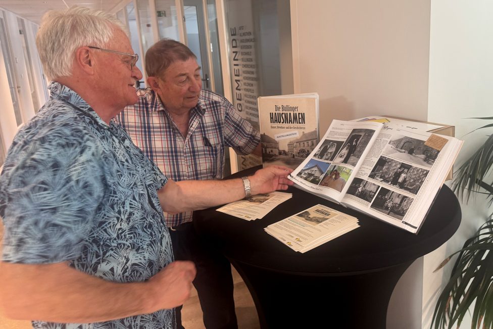 Willy Jost und Manfred Lauter blättern in dem Buch