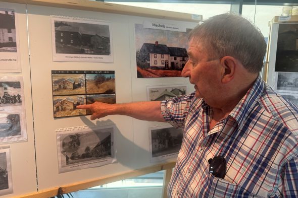 Manfred Lauter zeigt auf eines der Fotos