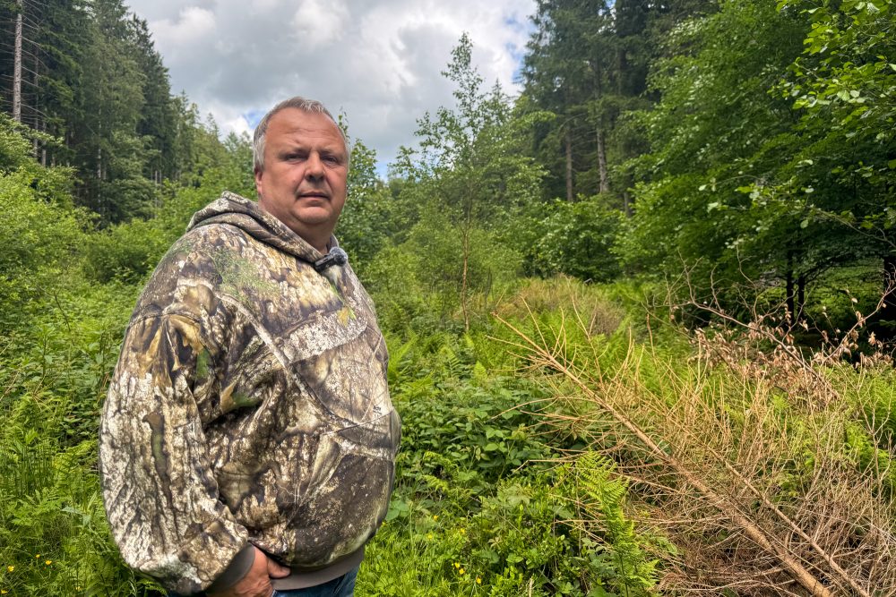 Andreas Tangeten steht in einem Waldstück mit viel Wildwuchs