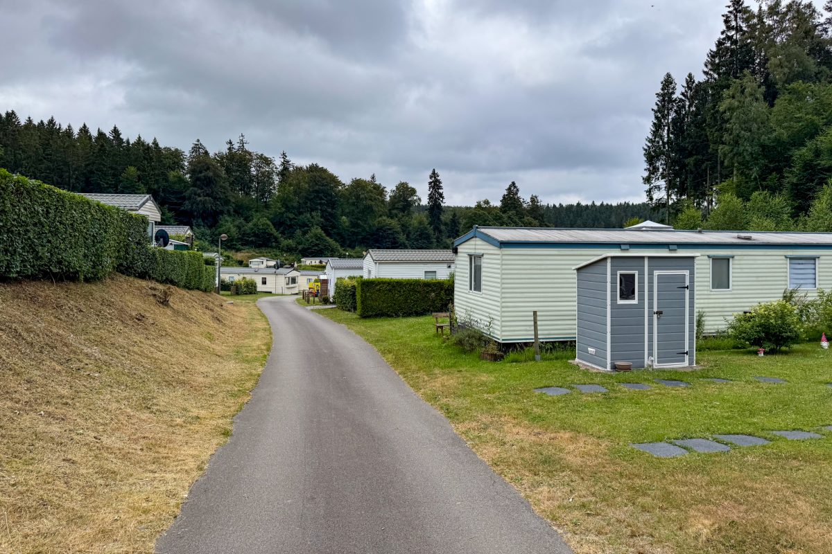 Asphaltierter Weg auf dem Campingplatz, nebenan stehen mehrere Mobilhomes