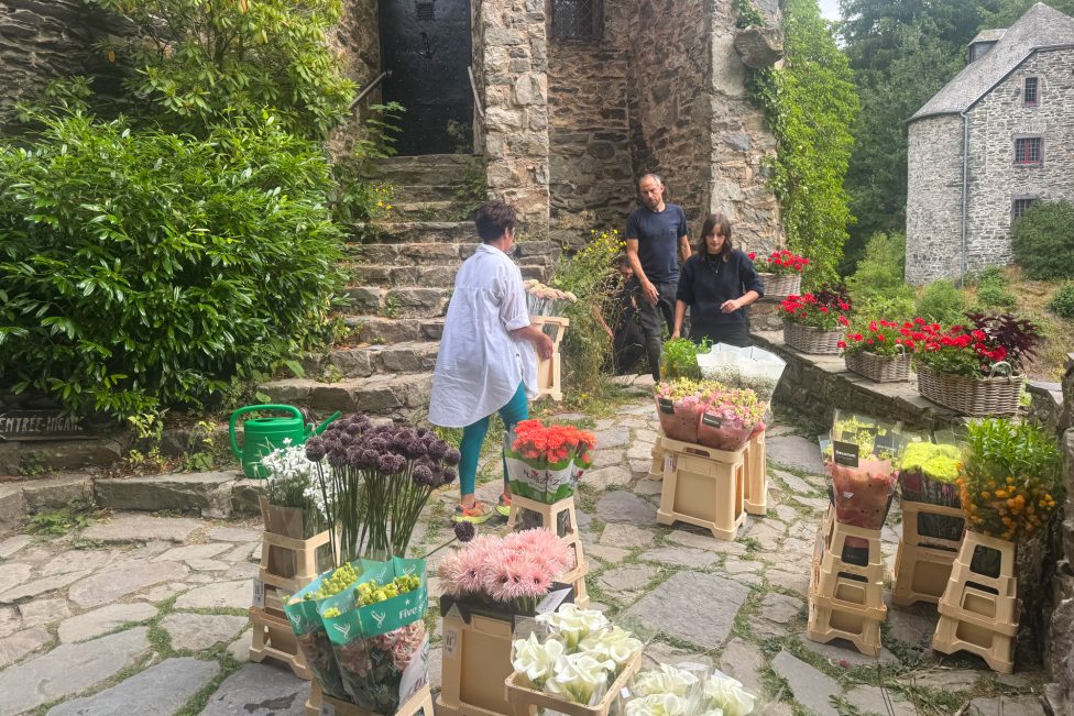 Menschen zwischen Blumen beim Aufbau von "Castelflora"