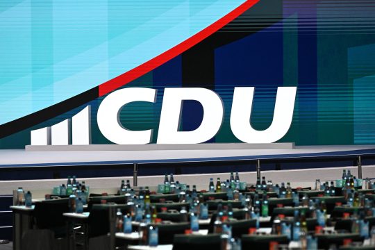 Logo der CDU mittels großer Buchstaben und Formen auf der Bühne eines Parteitags