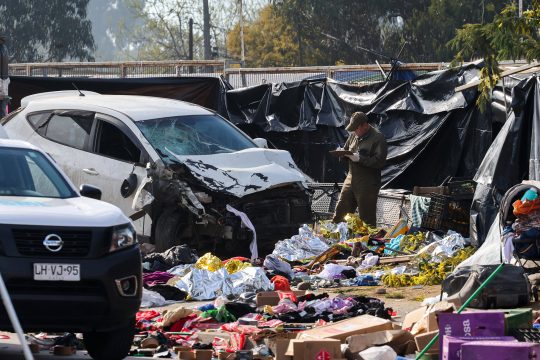 Ein Angehöriger der Carabineros arbeitet neben dem Fahrzeug, das auf dem Straßenmarkt mehrere Menschen angefahren hat.