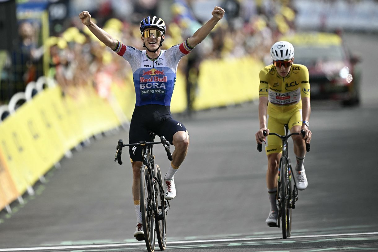 Remco Evenepoel überquert jubelnd die Ziellinie vor Tadej Pogacar