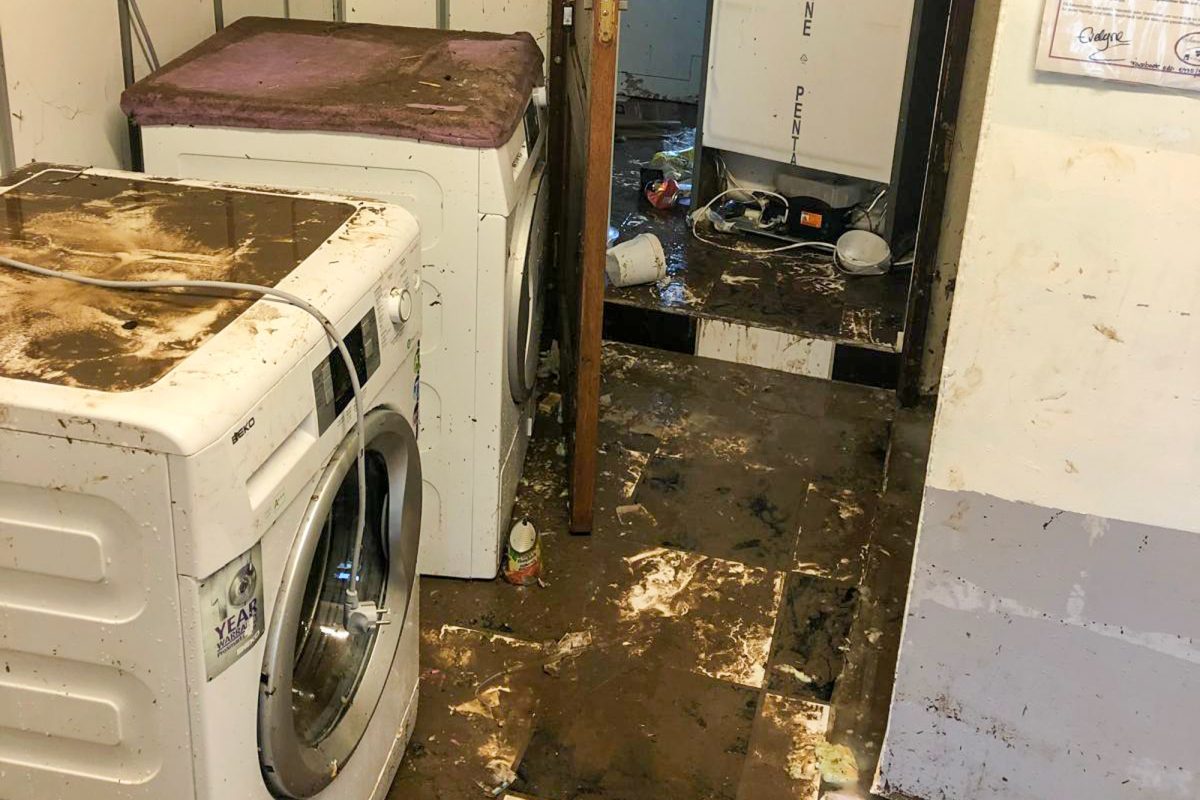 verschlammte Fußböden in der Wohnung, auch Waschmaschine und Trockner sind mit Schlamm bedeckt