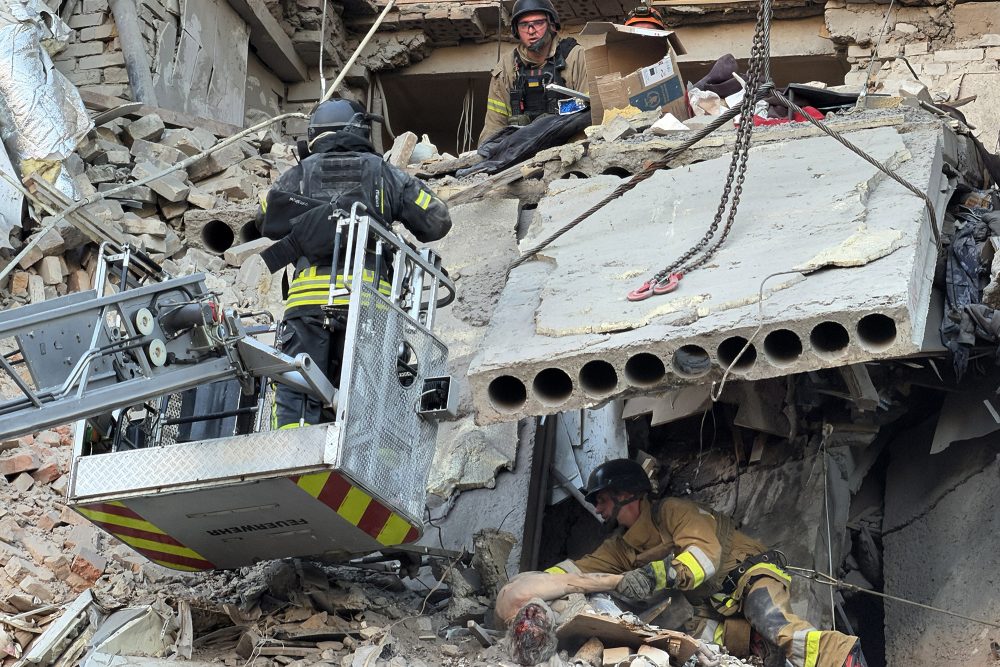 Rettungskräfte bergen Tote und Verletzte aus einem stark beschädigten Wohnhaus