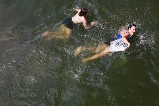 Zwei junge Frauen schwimmen in einem Badesee
