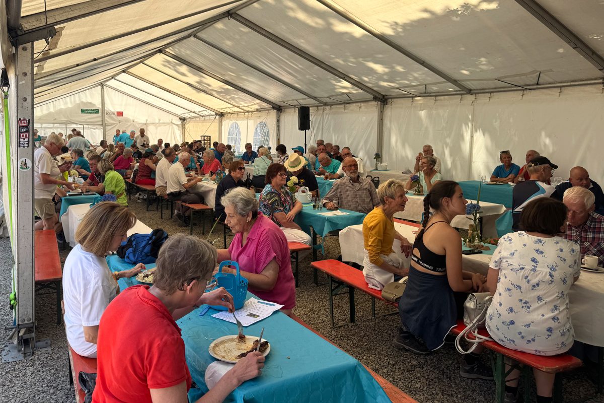 Menschen im Zelt nach der Wanderung, die essen und trinken