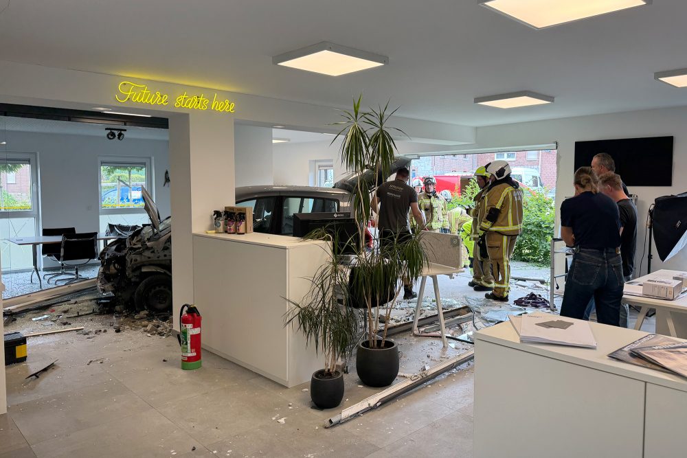 Feuerwehrleute begutachten die Schäden, im Hintergrund sieht man das Unfall-Auto