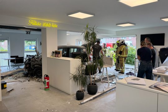 Feuerwehrleute begutachten die Schäden, im Hintergrund sieht man das Unfall-Auto