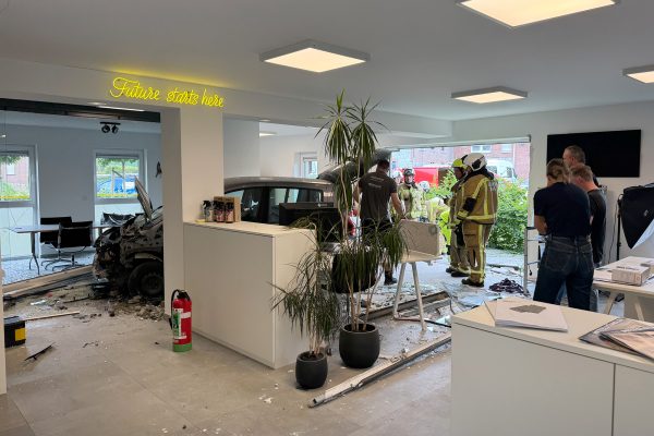 Feuerwehrleute begutachten die Schäden, im Hintergrund sieht man das Unfall-Auto