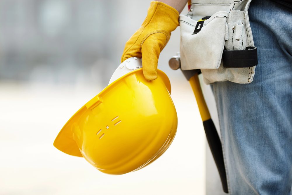 Hand eines Bauarbeiters mit Helm