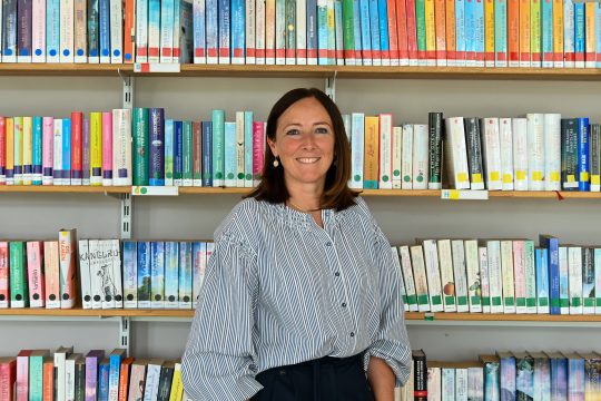 Catherine Ellenbecker vor einem Regal voller Bücher