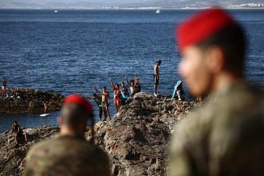 Spanische Soldaten an der Exklave Ceuta beobachten eine Gruppe von Migranten