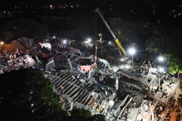 Luftaufnahme zeigt nächtliche Sucharbeiten über eingestürztem Gebäude, teilweise mit Kran