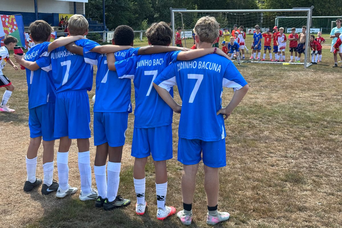 Junge Spieler von hinten stehen Arm in Arm in einer Reihe