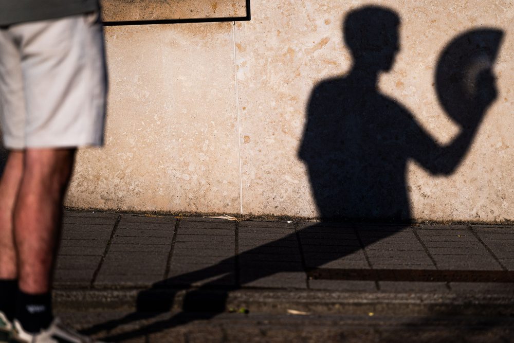 Mann mit Fächer vor einer Wand