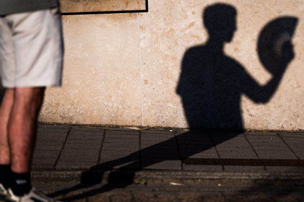 Mann mit Fächer vor einer Wand