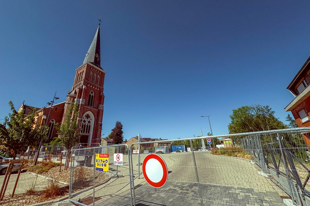 Bauzaun am Kirchplatz, links im Bild die Kirche