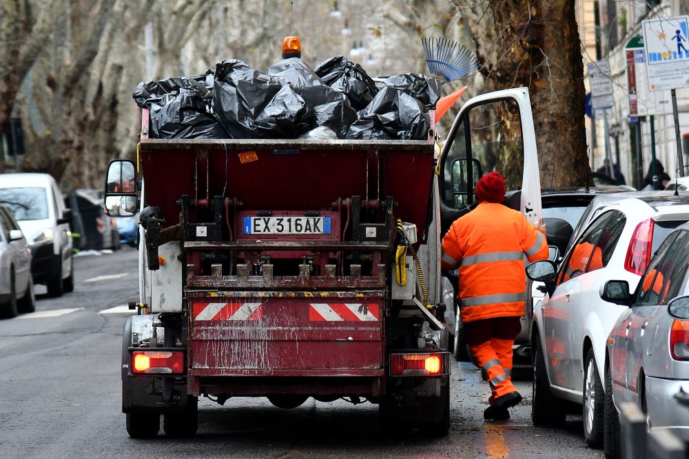 Voll beladener Müllwagen mit einem Mitarbeiter der Müllabfuhr in Rom