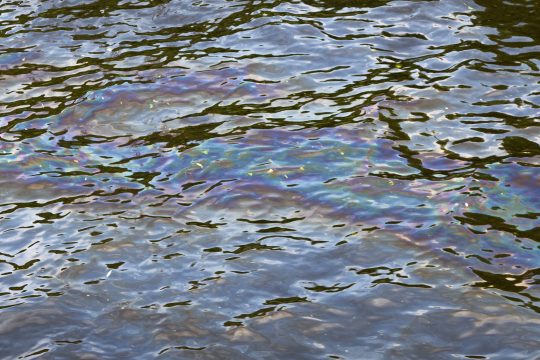 Ausgelaufenes Öl auf Wasser