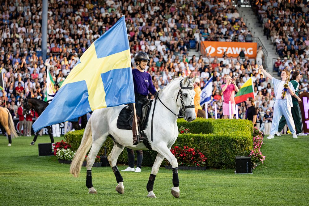 Eröffnungsfeier der Reit-WM 2026 in Aachen: Reiterin mit schwedischer Flagge reitet auf Pferd in die Arena