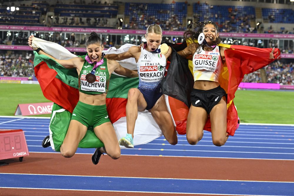 die drei Medaillengewinnerinnen springen nach dem Finale im Dreisprung der Frauen mit ihren jeweiligen Flaggen in die Höhe