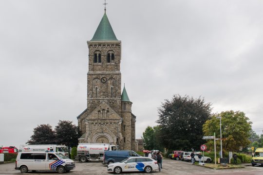 Kirche in Sourbrodt, davor steht unter anderem ein Polizeiauto