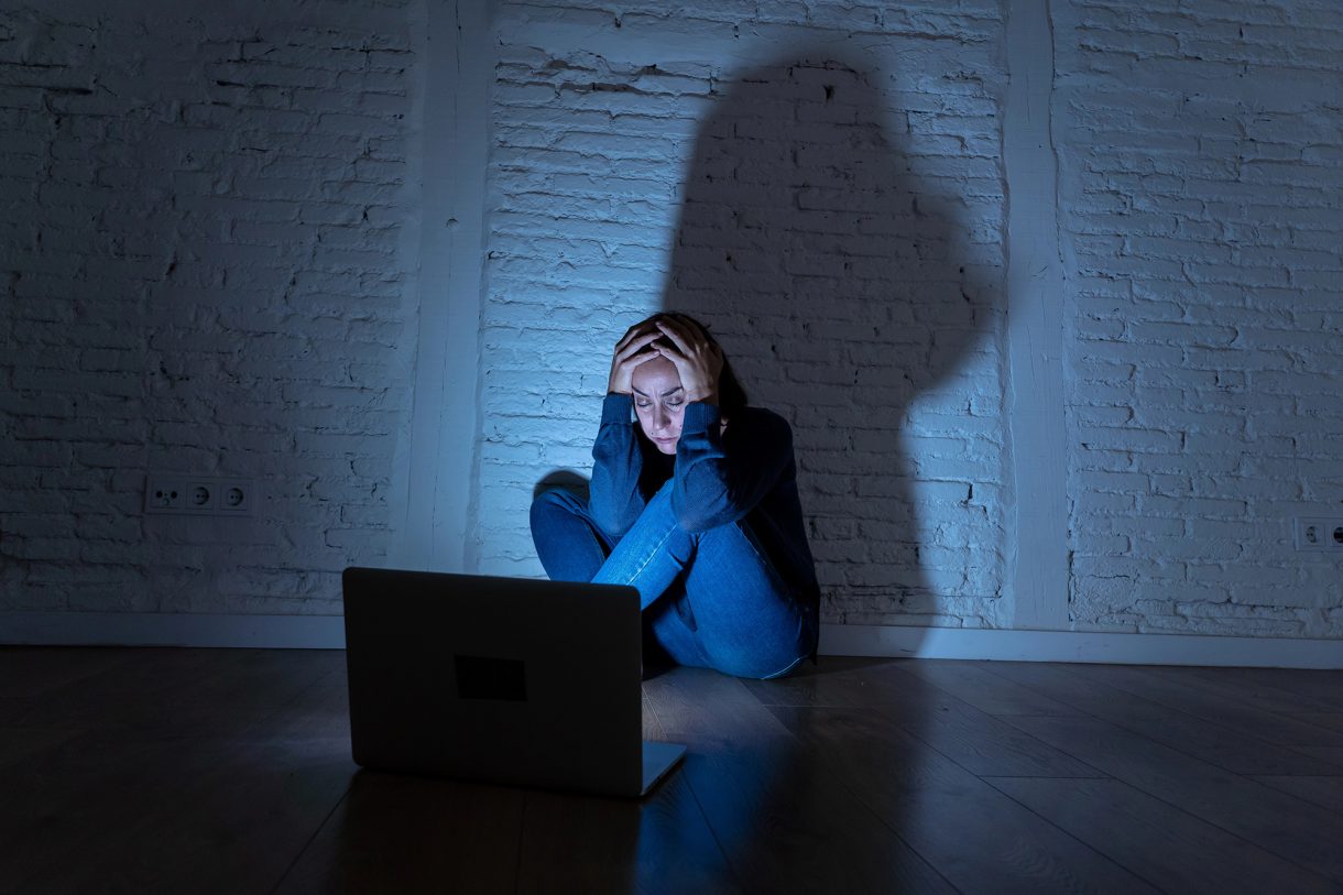 Frau in Angst vor Laptop wegen Stalking