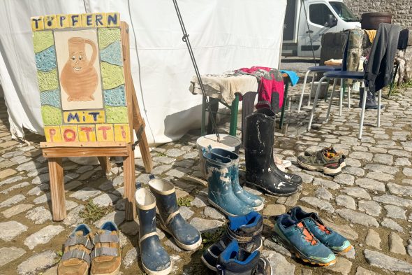 Schuhe und Stiefel der Teilnehmenden auf dem Gelände der Burg