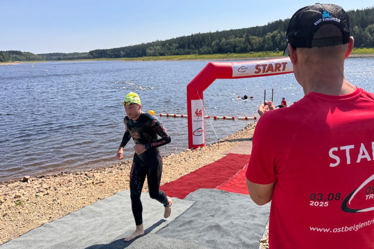 Triathlet kommt aus dem Wasser heraus und ist in der Wechselzone, im Vordergrund ein Kampfrichter