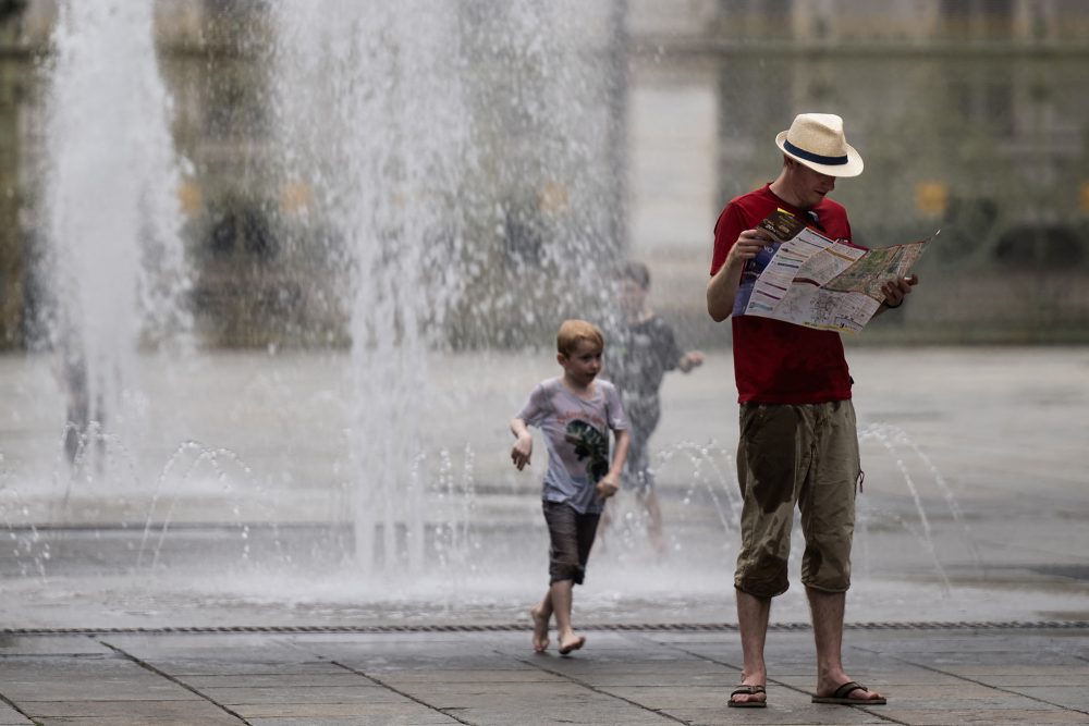 Mann und Kind an einem Springbrunnen in Turin