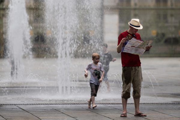 Mann und Kind an einem Springbrunnen in Turin