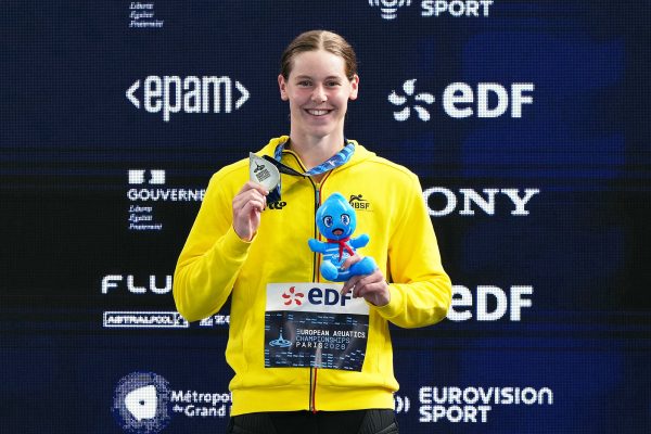 Roos Vanotterdijk mit Silbermedaille um den Hals auf dem Podium, in einer Hand hält sie ein Maskottchen