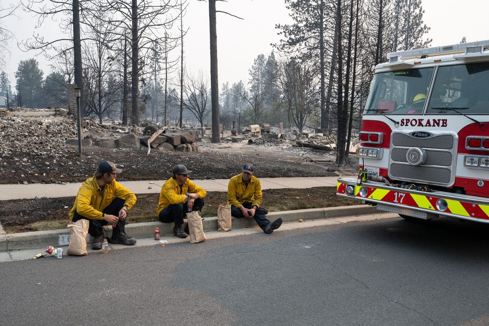 Feuerwehrleute bei einer Pause vor verbranntem Wald im Bundesstaat Washington