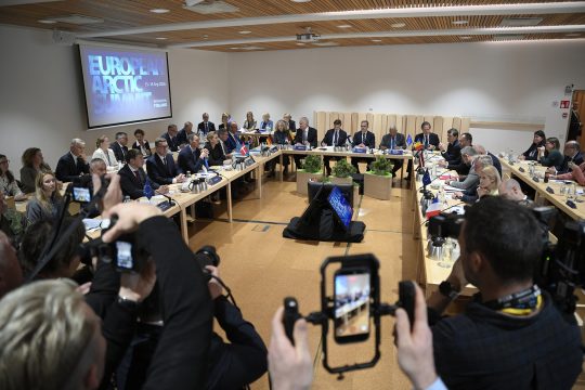 Teilnehmer des EU-Arktis-Gipfels sitzen an Tischen in einem Konferenzraum