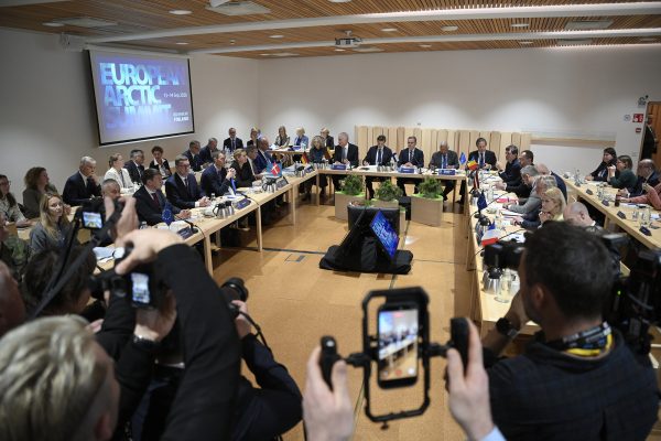 Teilnehmer des EU-Arktis-Gipfels sitzen an Tischen in einem Konferenzraum