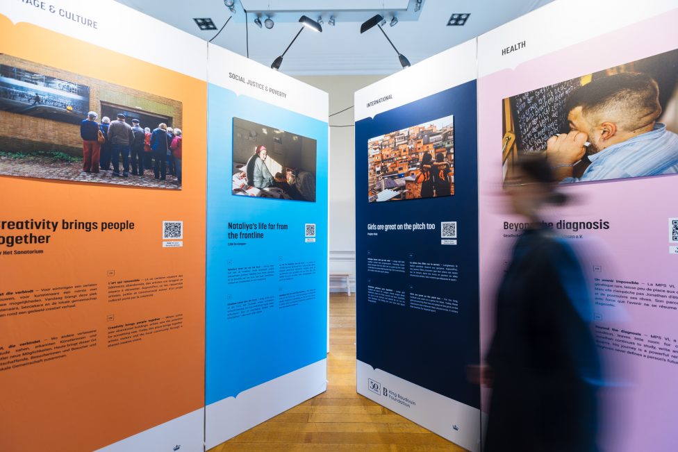 Besucherin vor Bildern in der Ausstellung "Geschichten, bei denen einem das Herz aufgeht“