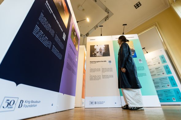 Besucherin vor Bildern in der Ausstellung "Geschichten, bei denen einem das Herz aufgeht“