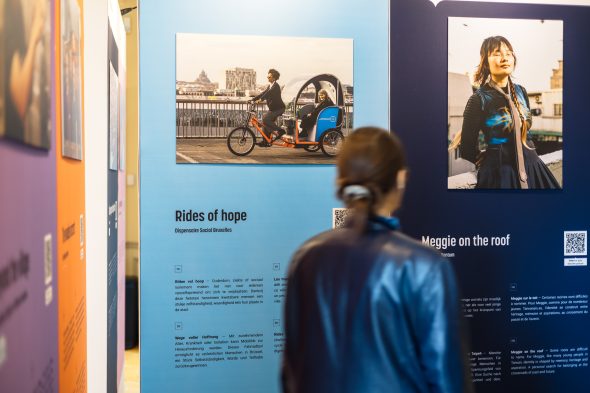 Besucherin vor Bildern in der Ausstellung "Geschichten, bei denen einem das Herz aufgeht“