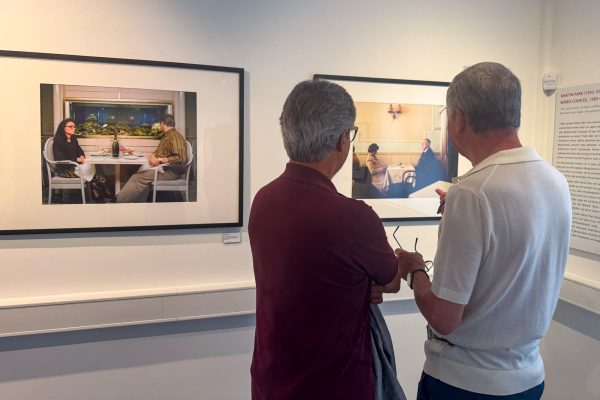 Zwei Besucher der Ausstellung schauen sich Fotos an