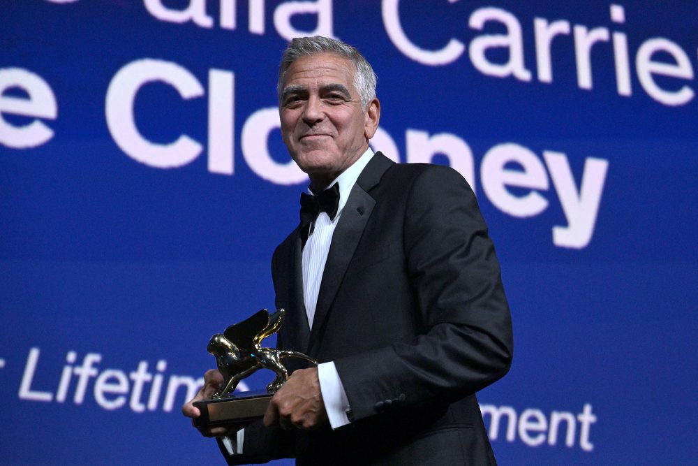 George Clooney hält den "Goldenen Löwen" in der Hand