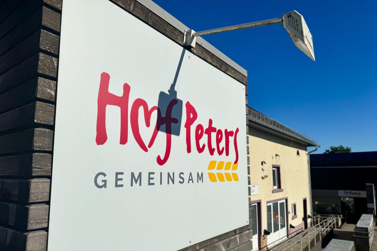 Banner mit Aufschrift "Hof Peters" und dem Wort "Gemeinsam" am Gebäude
