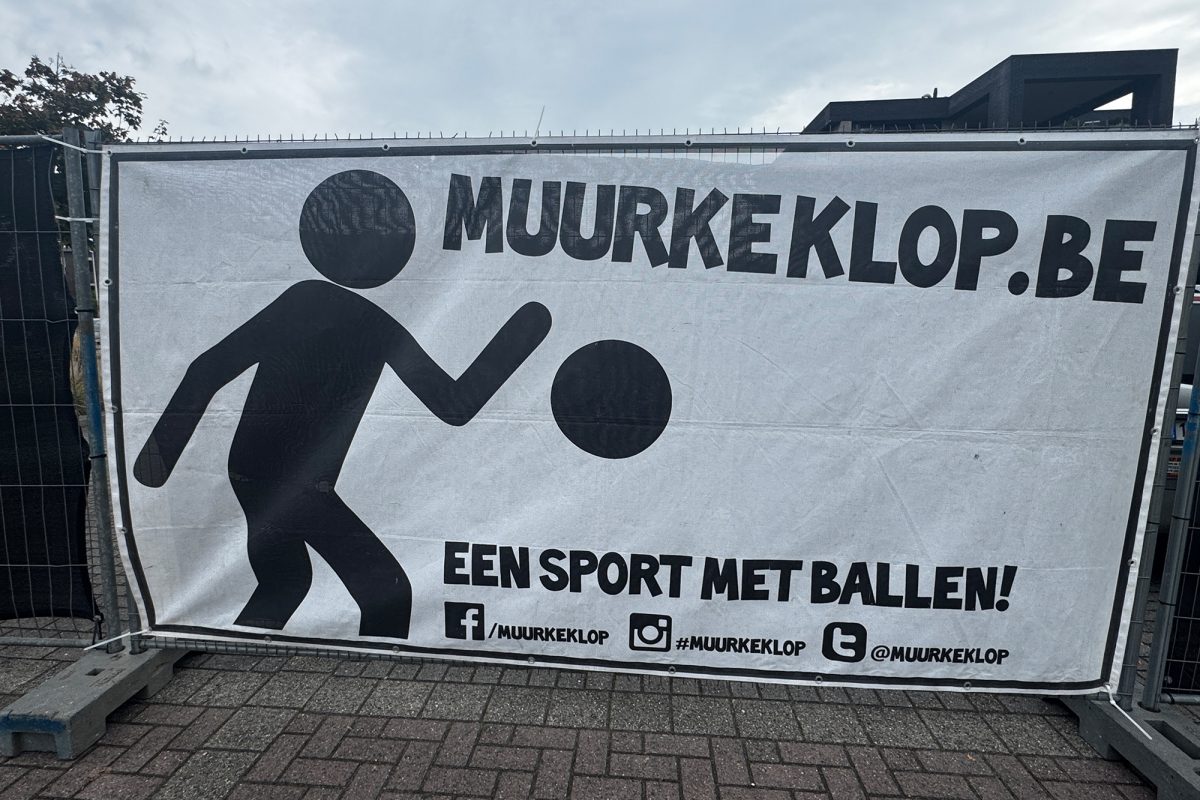 Banner mit der Aufschrift muurkeklop.be und einer gemalten Figur, die Mauerball spielt