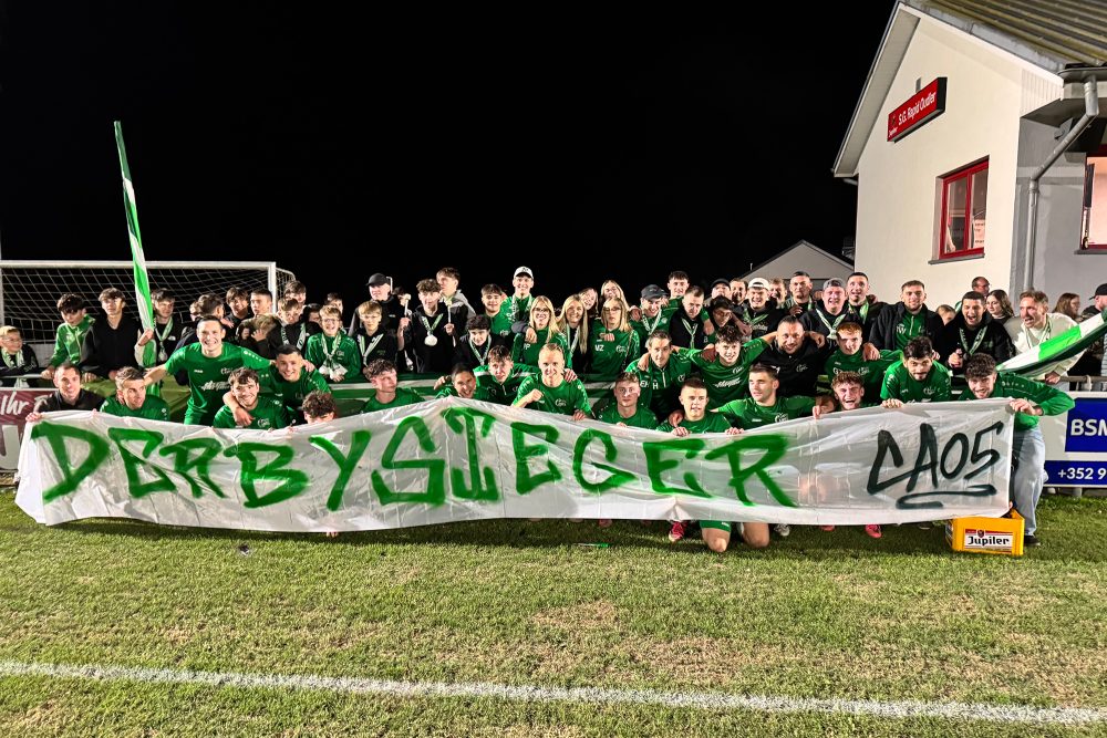 Die Ameler Mannschaft posiert fürs Gruppenfoto mit einem Banner, auf dem "Derbysieger" steht