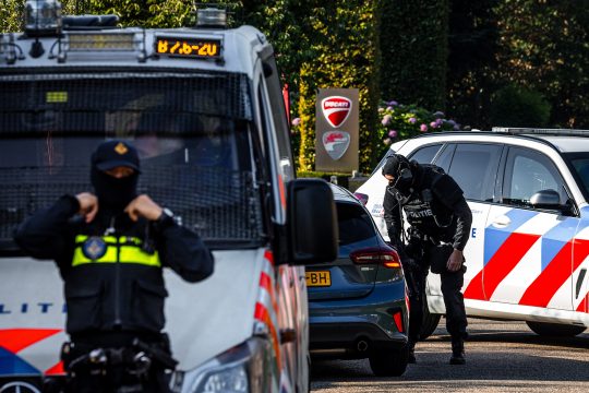 Schwer bewaffnete Polizeibeamte patrouillieren am Tatort in Overasselt