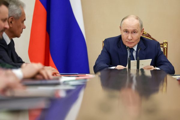 Blick über den langen Versammlungstisch auf Putin am Kopfende, links am Tisch weitere Versammlungsteilnehmer