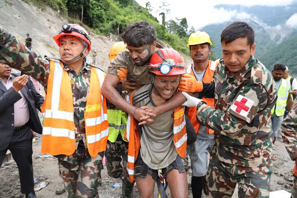 Soldaten tragen einen Arbeiter, während einer Rettungsaktion am Wasserkraftprojekt Trishuli-3A im nepalesischen Distrikt Rasuwa.